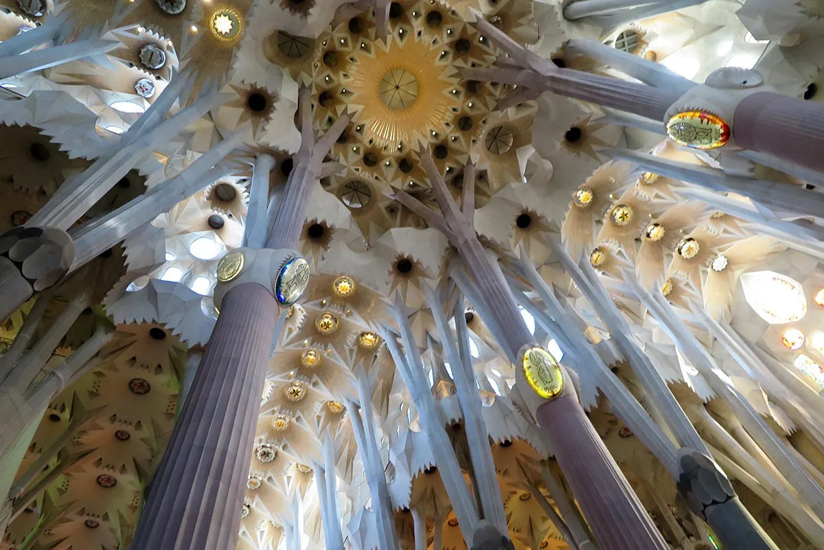 Heavily decorated ceiling of Sagrada Familia depicting trees in a forest