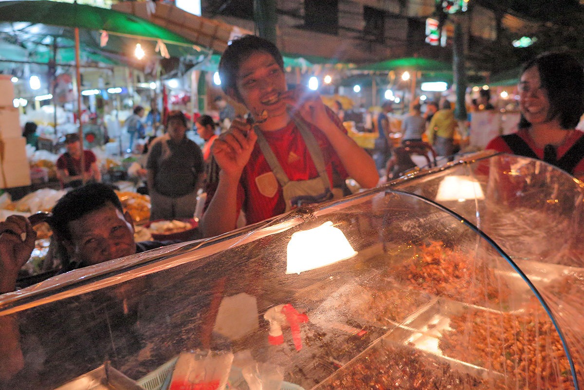 If you have no idea how to eat that grasshopper, the vendor will gladly show you! - street food in Bangkok