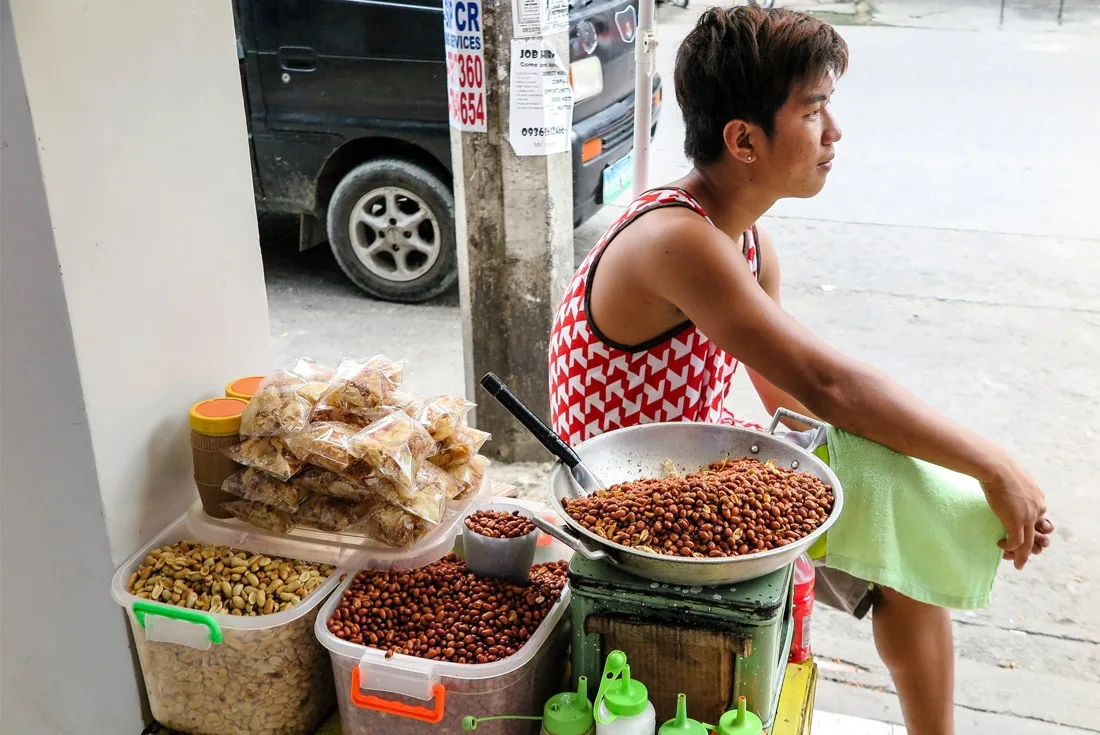 A man selling fried peanuts at Tacloban street market