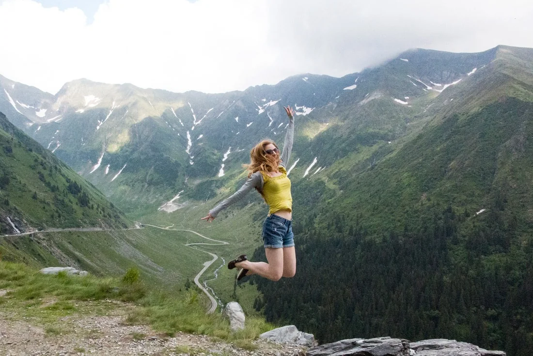 Veronika of TravelGeekery jumping above Transfagarasan Road