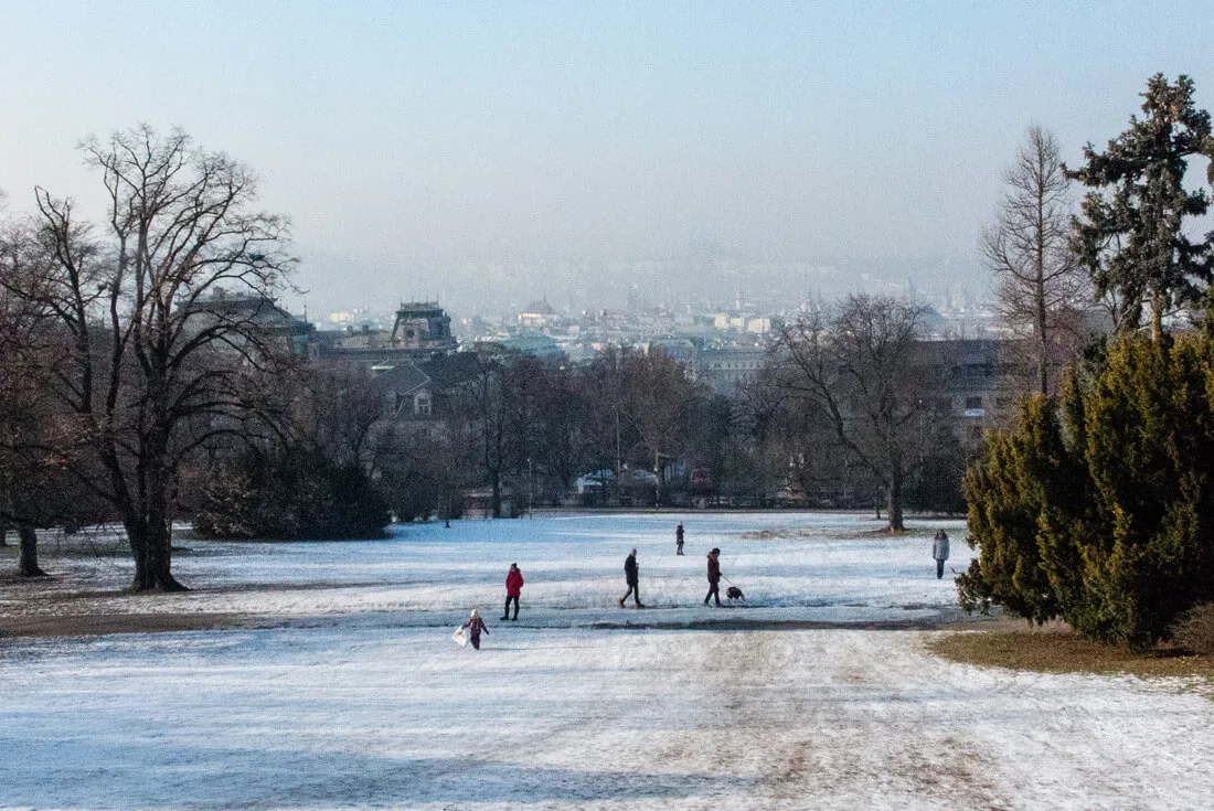 A small hill in a snowy Riegrovy Sady park serving as a fun slide for the kids!