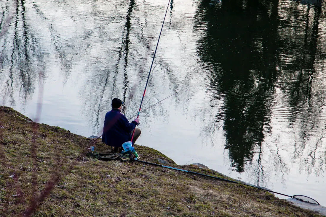 A fisherman fishing in the Ostravice River, near Ostrava city center