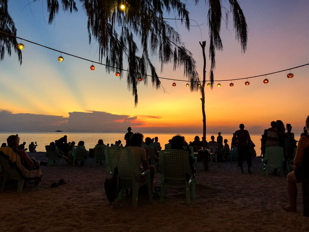 People gathered at a beach upon sunset
