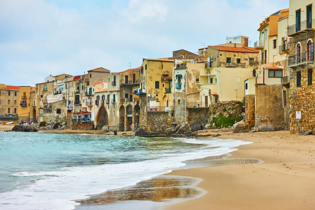 View of a beach with old houses in Cefalu, Sicily