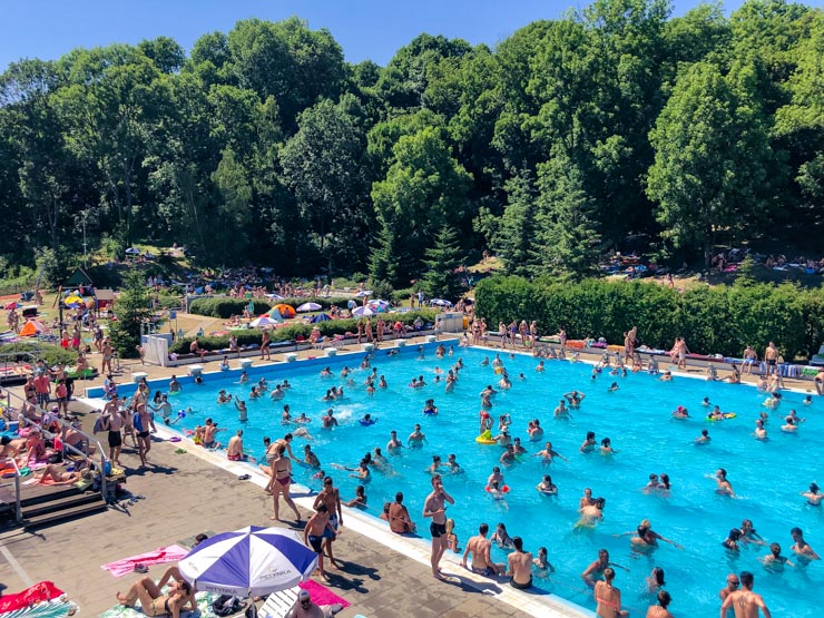 View of a busy outdoor swimming pool in Prague