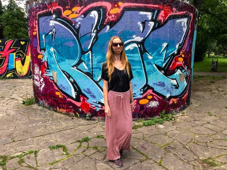 Posing in front of a graffiti covered wall wearing a long skirt