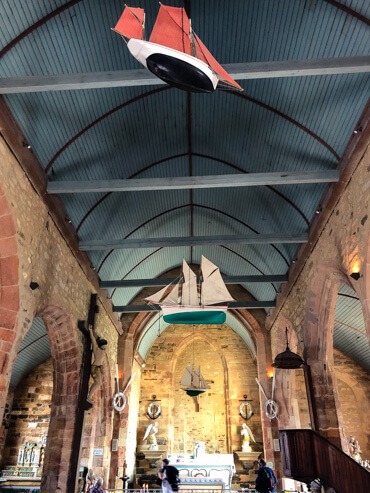 Little boats hanging from the ceiling of a church