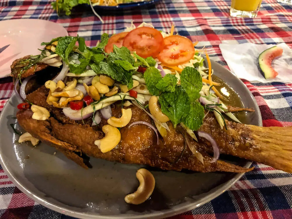 Deep fried fish served with herbs and cashew nuts at a Thai restaurant