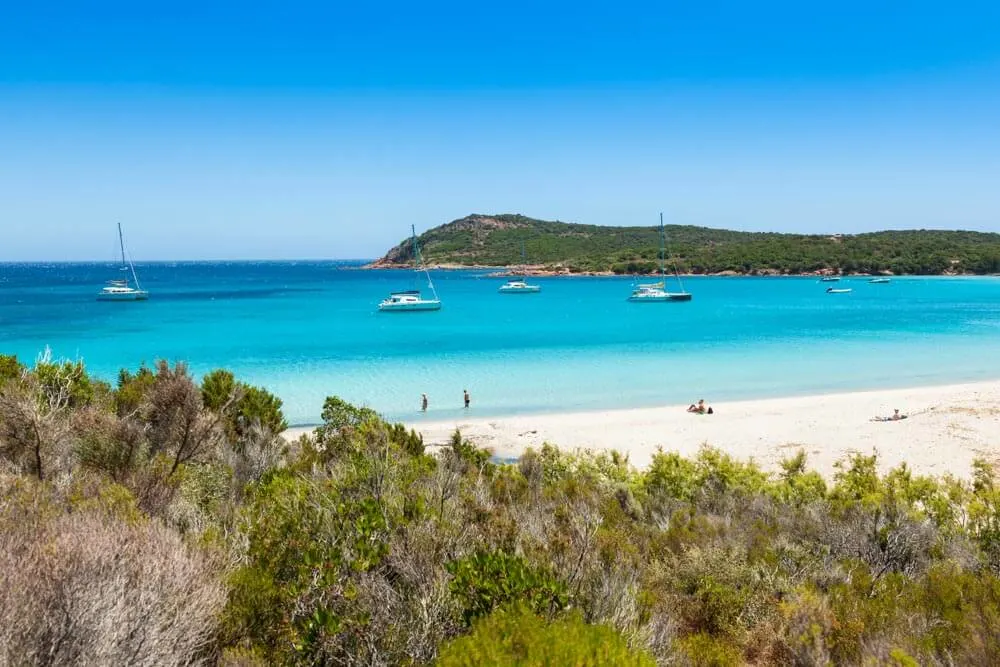 Perfect white sand beach in Corsica with yachts