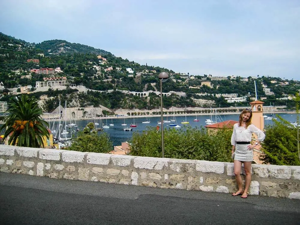 Veronika from Travel Geekery posing with the view of Villefranche, a seaside village in the French Riviera