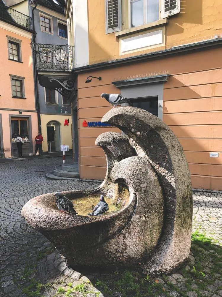 Pigeons enjoying a water fountain