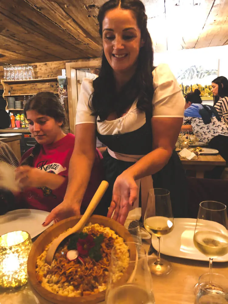 An Austrian woman presenting a local cheese specialty