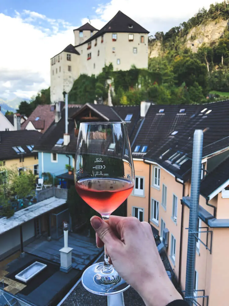 A glass of wine with a view of a castle