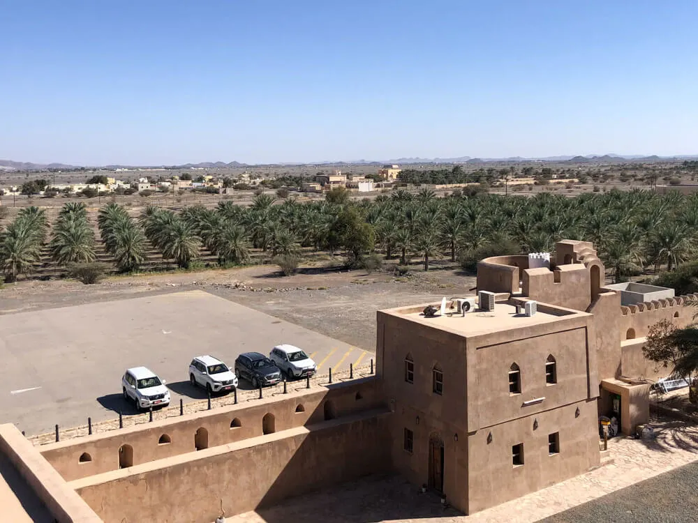 Cars parked by a castle in Oman
