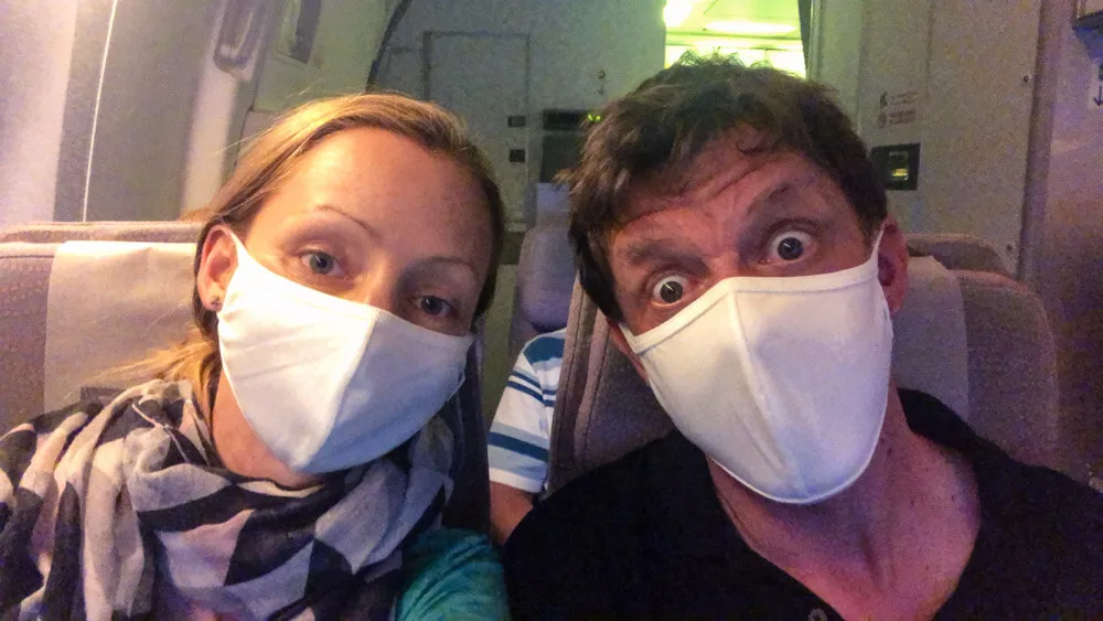 Veronika and her husband on a flight with face masks on.