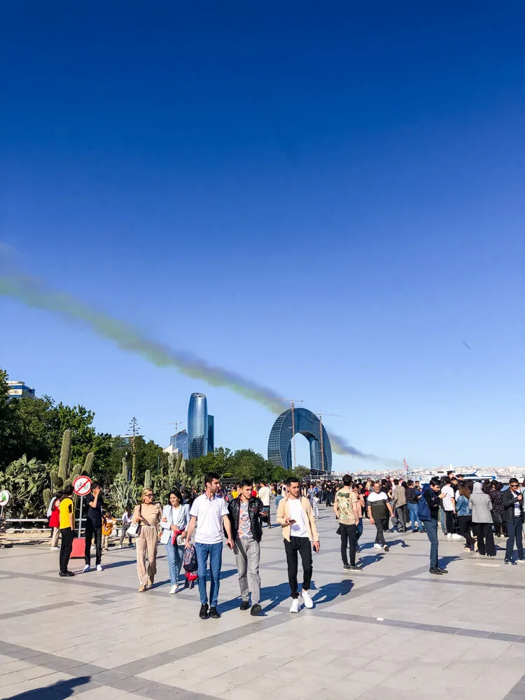 Locals in Baku walking on Baku Boulevard with skyscrapers on the horizon