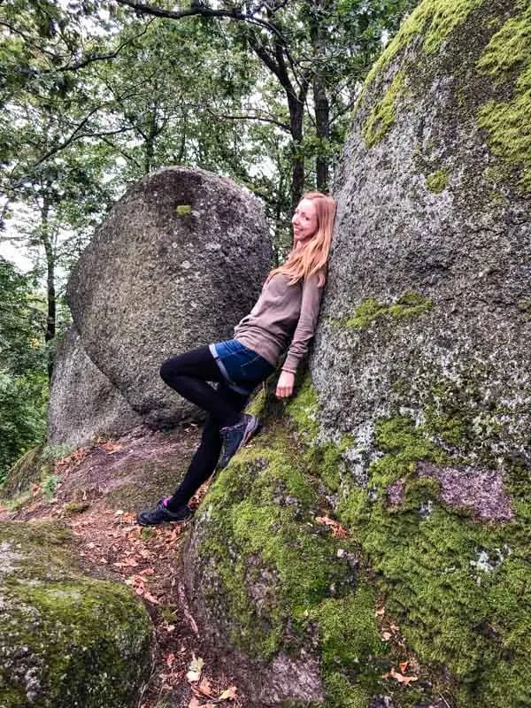 Veronika of TravelGeekery leaning against a rock in a nature setting