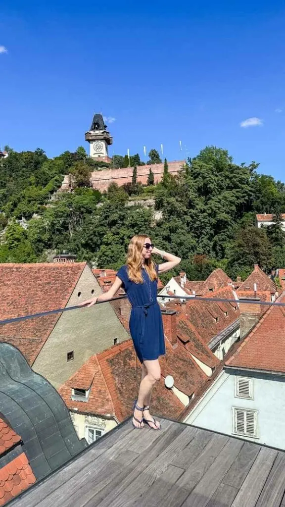 Veronika posing on a viewing platform with Graz Clock Tower in the background