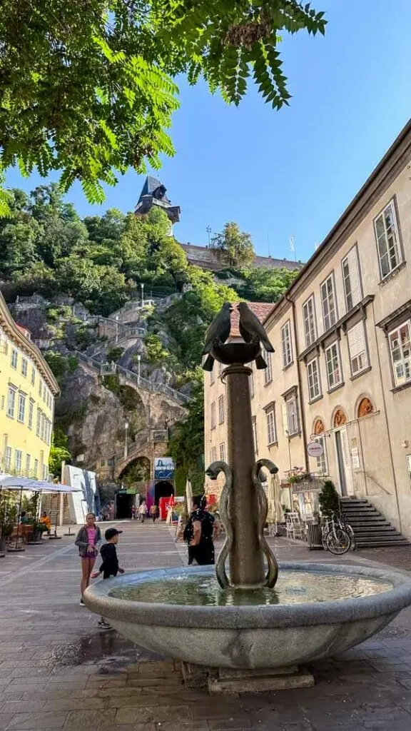 A view of a fountain near a staircase to get to Schlossberg Hill in Graz Austria