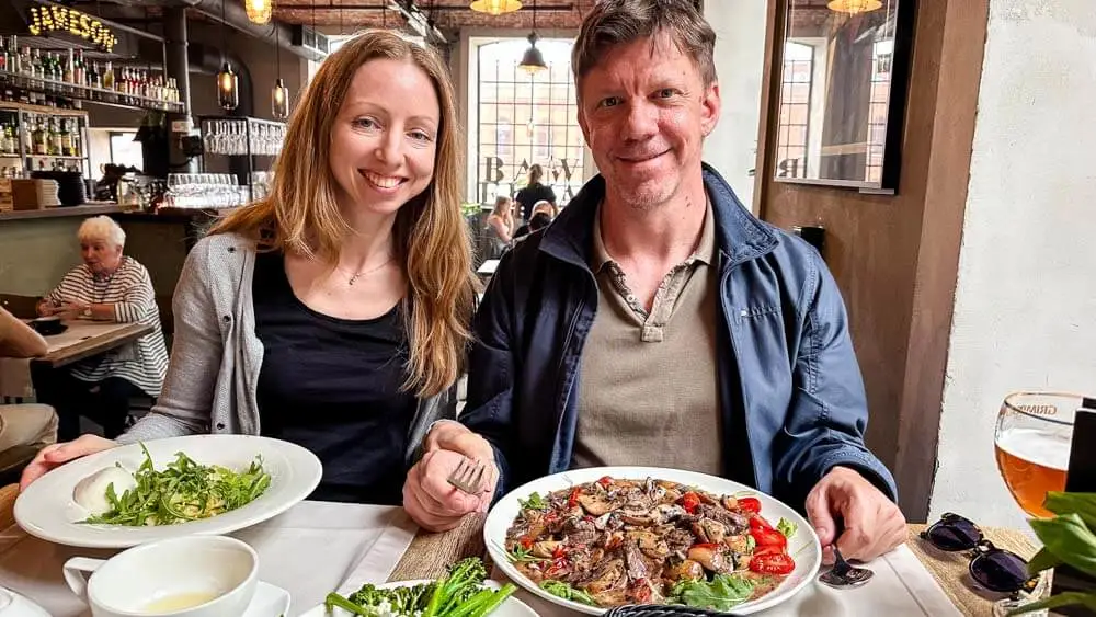 Two people enjoying a meal and smiling into the camera