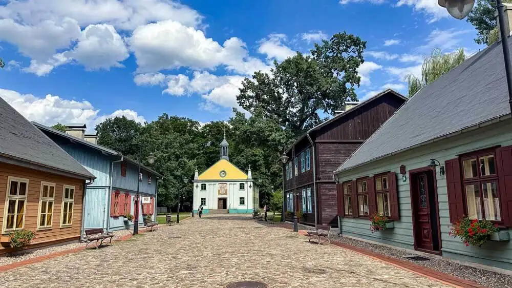 historical wooden houses and a church in an open air museum in Lodz Poland