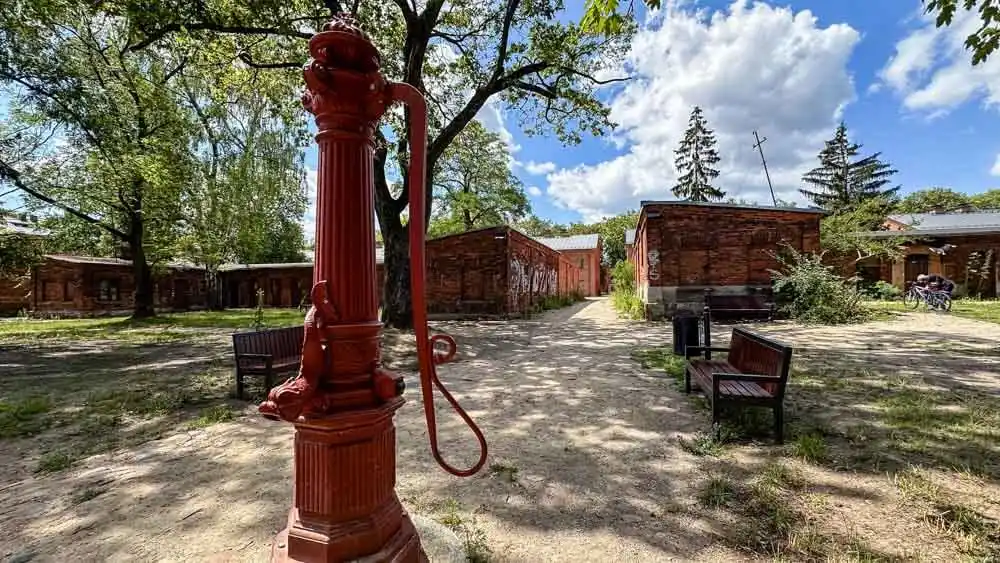 a view of another revitalized factory complex with a lot of greenery and a large red pump in the front