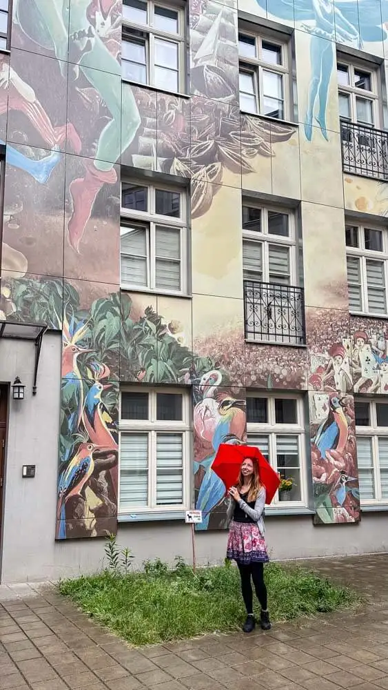 Veronika posing with a large mural on a building in Lodz Poland