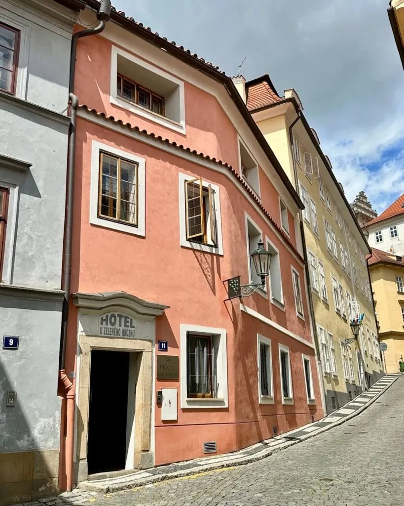 Peach-colored historic building housing Hotel U Zeleného hroznu on a quiet cobblestone street in Prague’s Malá Strana.