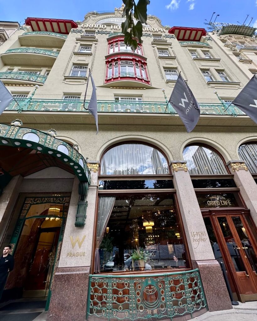 Ornate facade of W Prague, formerly Grand Hotel Europa, with colorful Art Nouveau balconies and elegant window details.