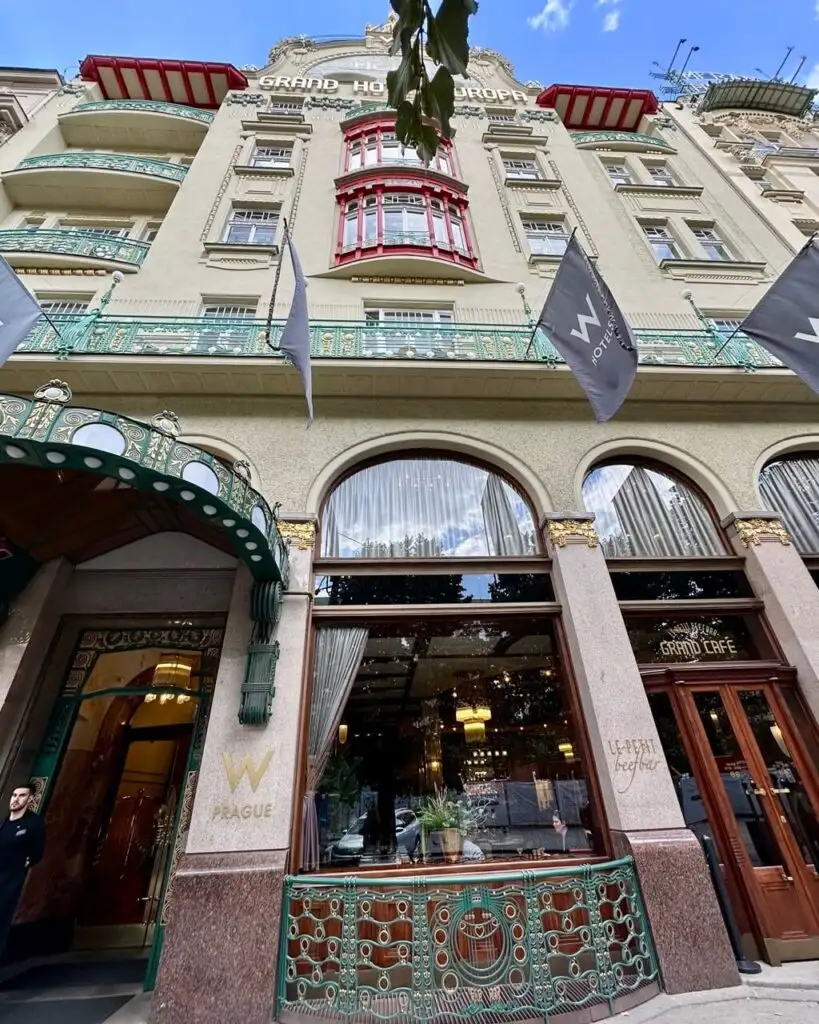 Ornate facade of W Prague, formerly Grand Hotel Europa, with colorful Art Nouveau balconies and elegant window details.