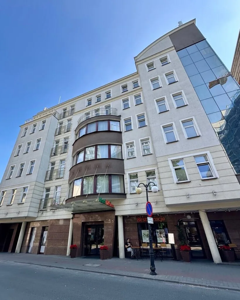Street view of Hotel DeSilva, a multi-story building with a curved facade and street-level restaurant.