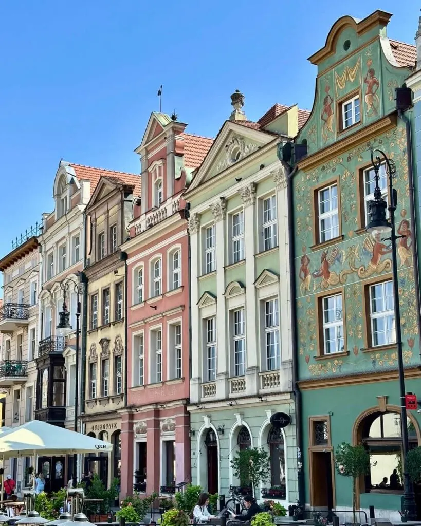 Close-up of pastel-colored historic buildings with ornate facades and decorative murals in Poznan’s Old Town.