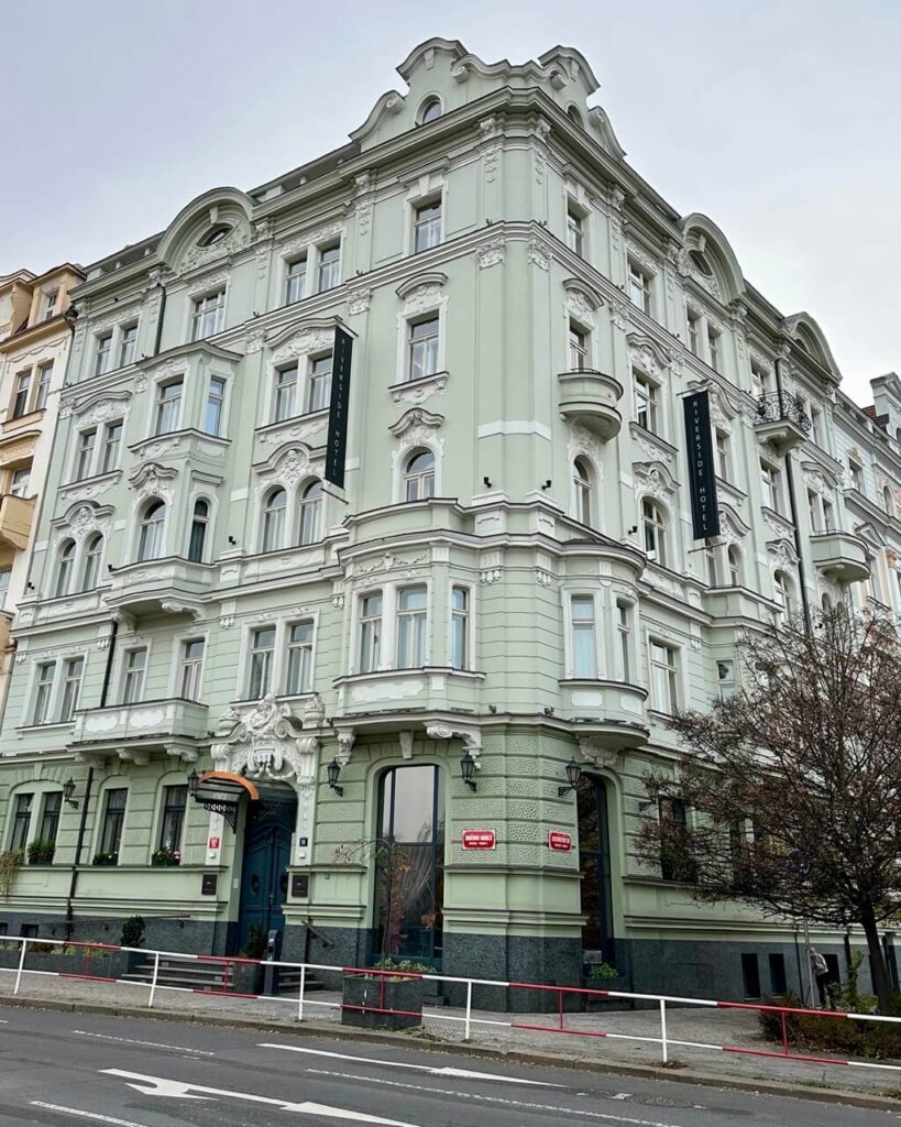 Riverside Prague hotel in a mint green art nouveau building on a street in a scenic Prague neighborhood.