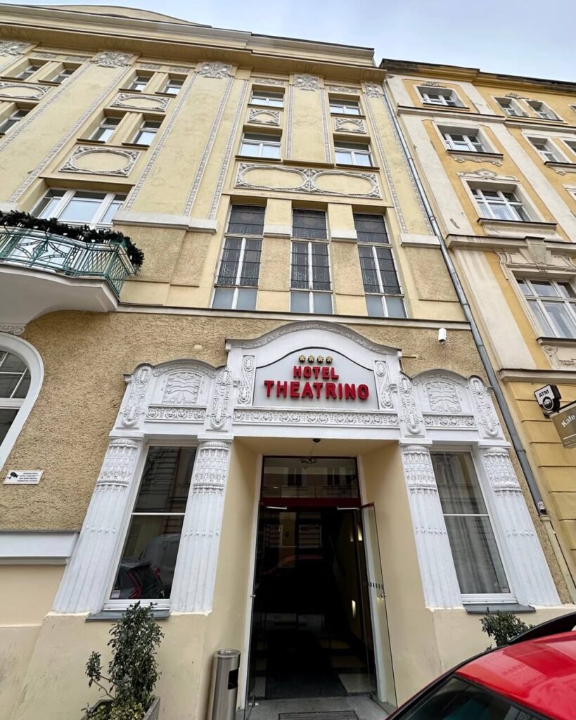 Hotel Theatrino Prague with yellow historic facade and decorative white entrance in a charming Prague neighborhood.