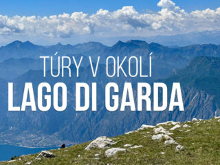 Panoramatický výhled z turistické trasy u Lago di Garda s kamenitou zelenou loukou nad jezerem a vrstvenými modrými horami pod jasnou oblohou plnou bílých mraků. Text říká „TÚRY V OKOLÍ LAGO DI GARDA“.